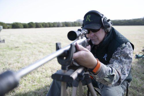Ted Nugent looking down the scope of a rifle