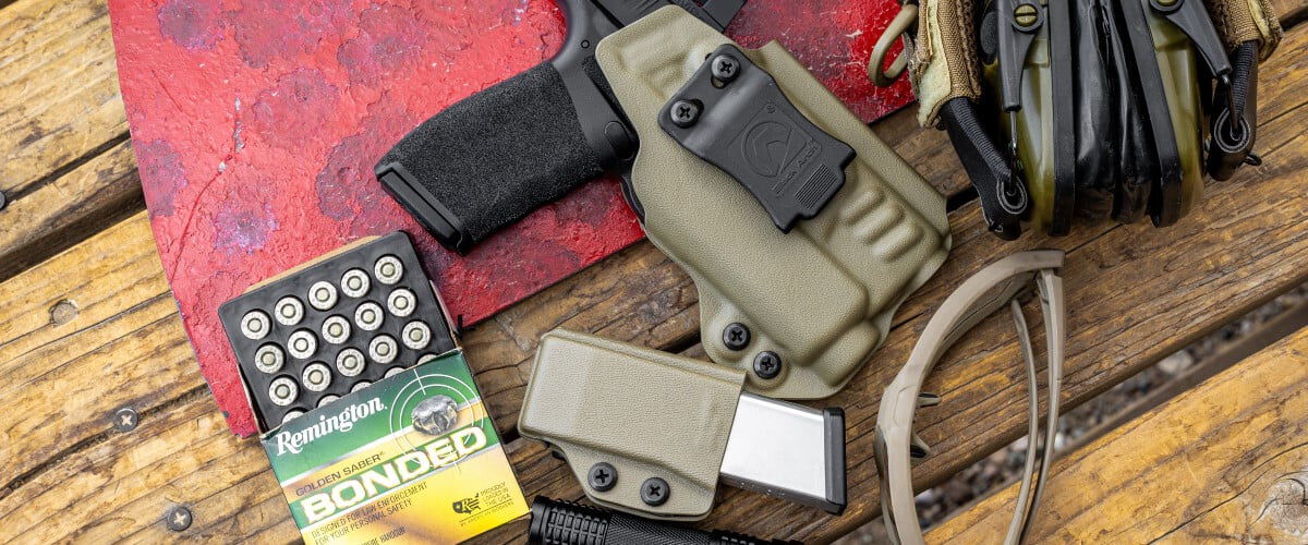 Golden Saber Bonded open box next to a handgun, magazine, eye and ear protection