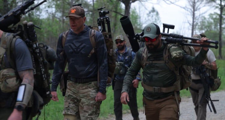 Dustin with other shooters walking on a road with their rifles