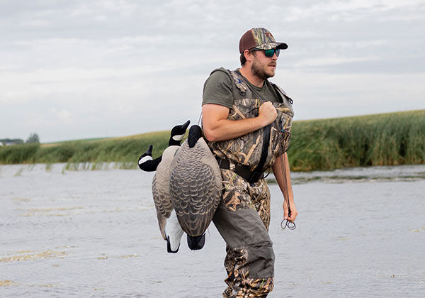 Josh Peck walking in water with decoys