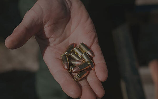 man carrying dead turkey on his back surrounded by trees