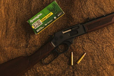 lever action rifle laying on a table with a box of Core-Lokt 360 Buckhammer and cartridges