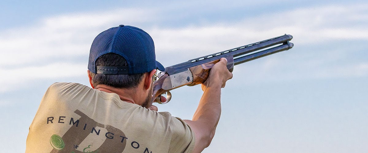 Shooter aiming shotgun while outside