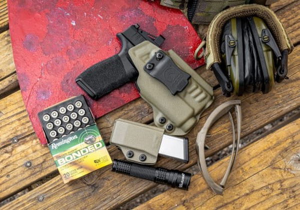 Golden Saber Bonded open box next to a handgun, magazine, eye and ear protection