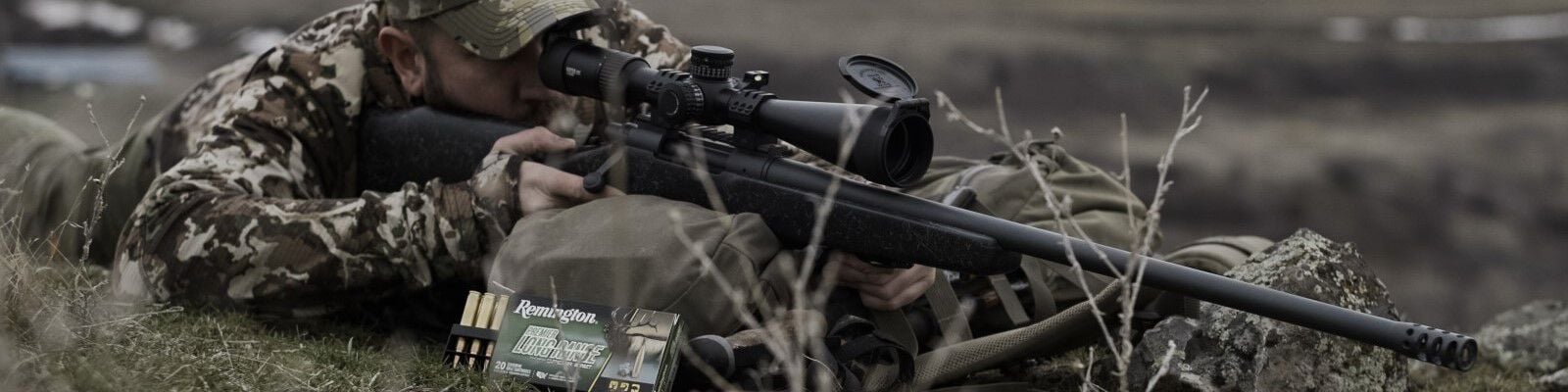 hunter looking down a rifle rested on a backpack