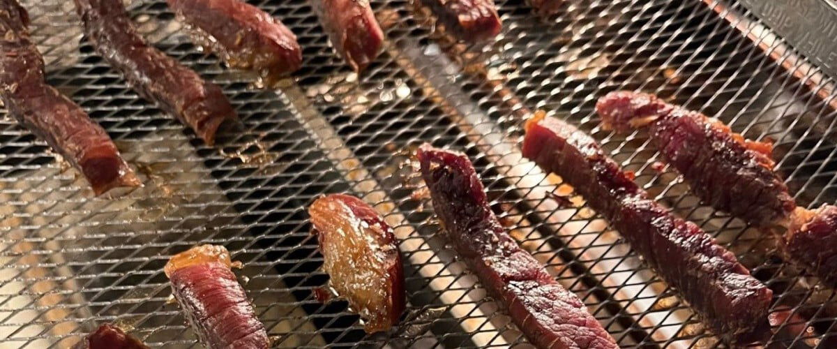 deer jerky laying on a wire mesh rack