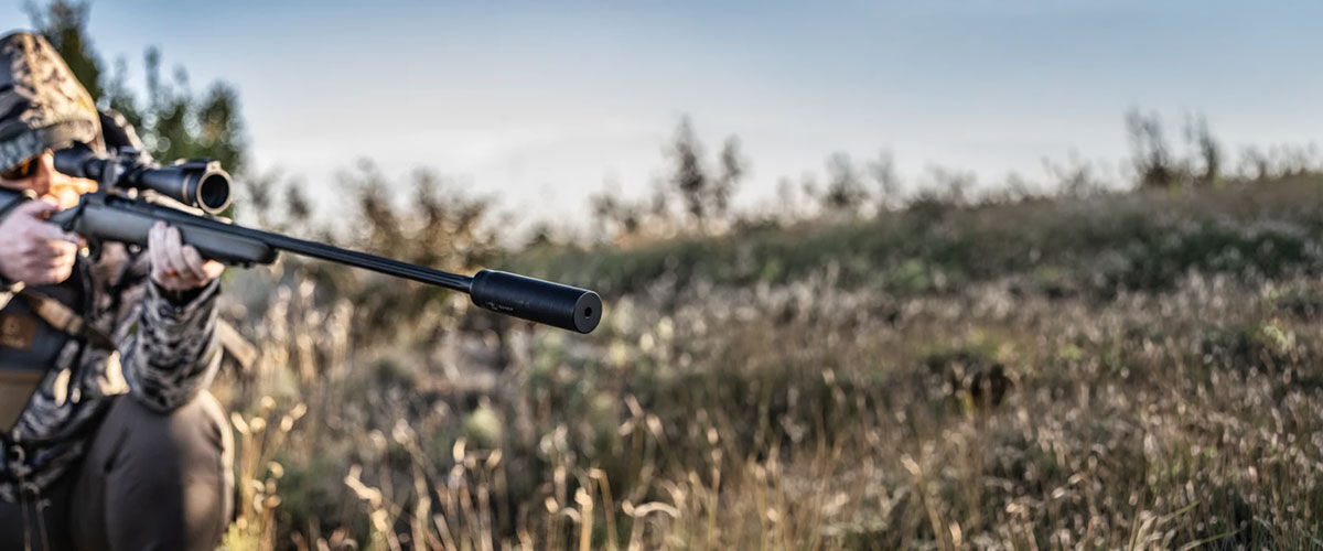 hunter aiming suppressed rifle