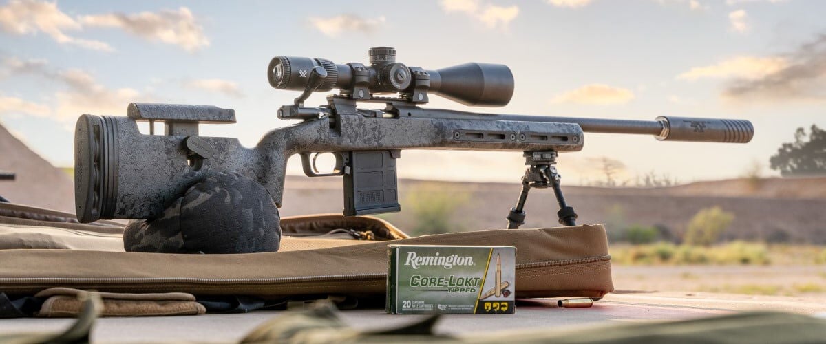 Rifle sitting on a stand on the group with a box of Core-Lokt Tipped