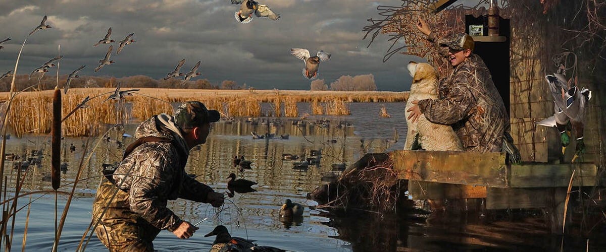 duck hunters setting decoys by a buck blind