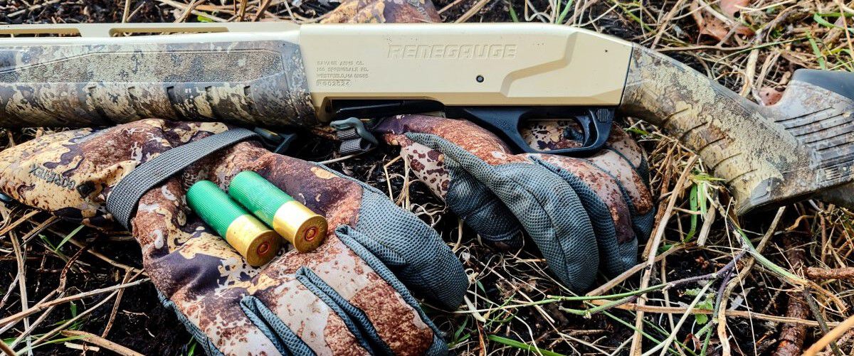 Remington Premier Bismuth laying on a glove in the grass with a shotgun 