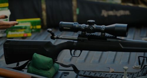 rifle in a gun rest on a pickup tailgate