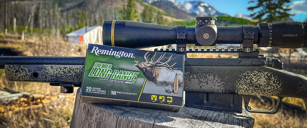 Premier Long Range box next to a rifle on a tree stump