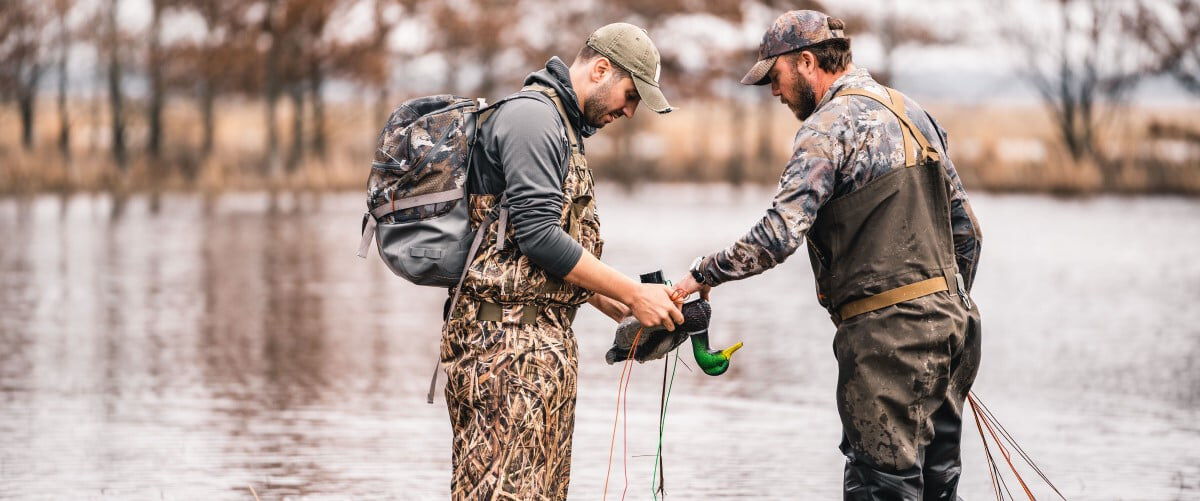 2 hunters setting up decoys in the water