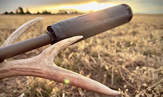 suppressor on a rifle laying on a deer antler