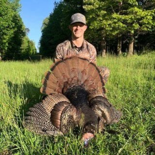 Matt Hewet kneeling behind a turkey