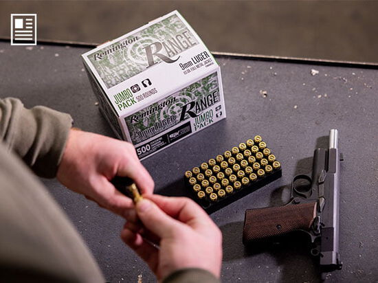 Remington Range box and cartridge tray sitting on a table with a handgun