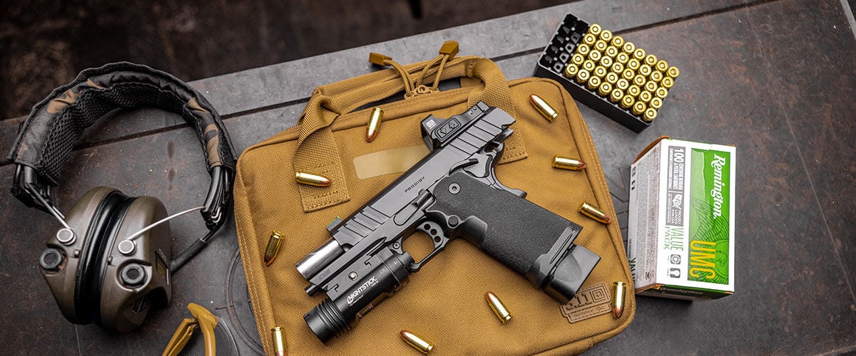 UMC handgun box and cartridges on a table with a pistol and ear protection