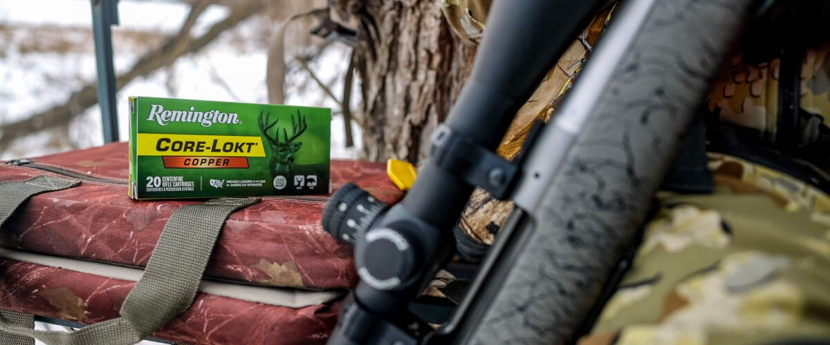 rifle laying on a hunter's leg next to a box of Core-Lokt Copper