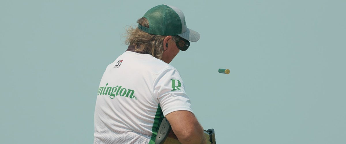 shooter wearing a Remington shirt ejecting a shotshell from a shotgun