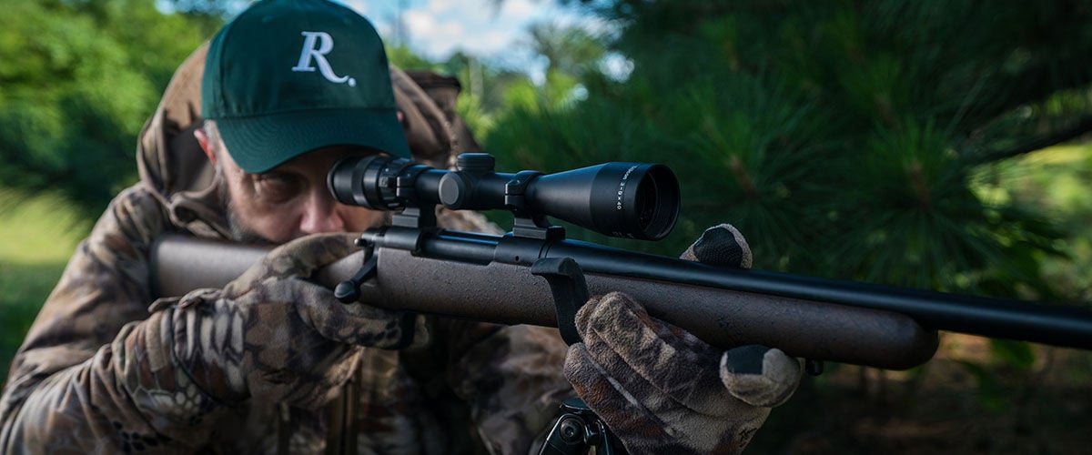 hunter looking through a rifle scope