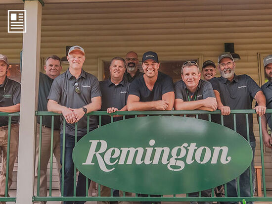 crowd of people standing on the porch of the Remington Gun Club