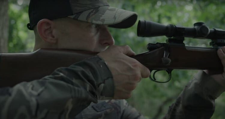 Matt Hewett looking down the scope of a rifle