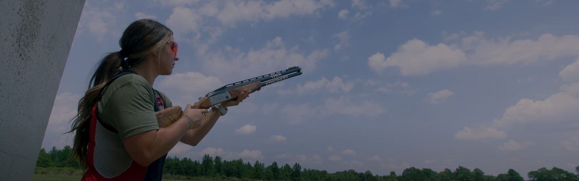 Julia Stallings looking into the sky will holding a shotgun outside