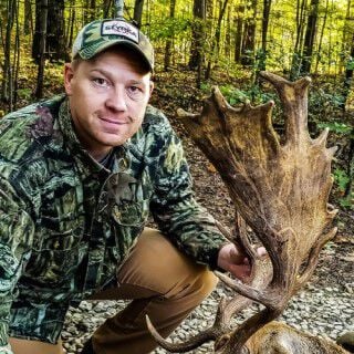 Adam Wies holding the antler of an animal.
