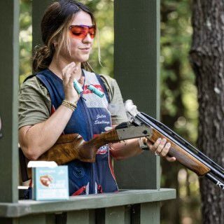 Julia Stalling catching shotshells ejected from her shotgun