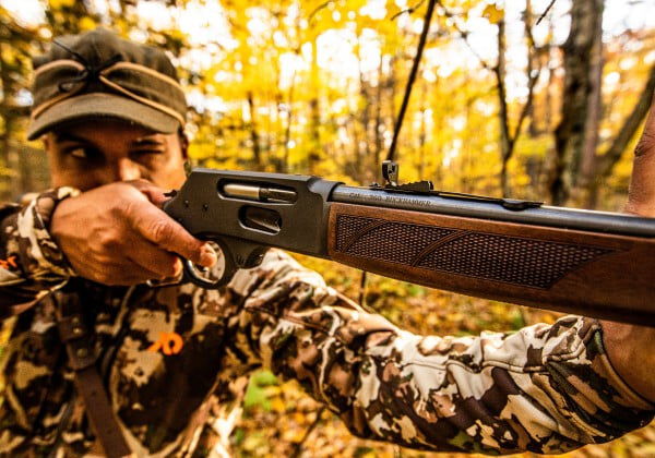 hunter aiming a lever action rifle