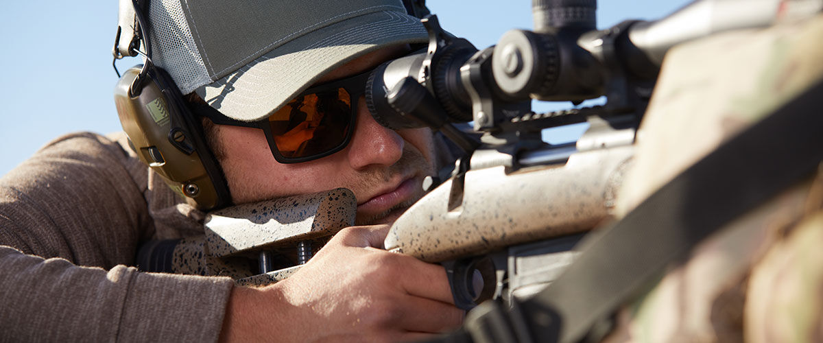shooter looking down the scope of a rifle