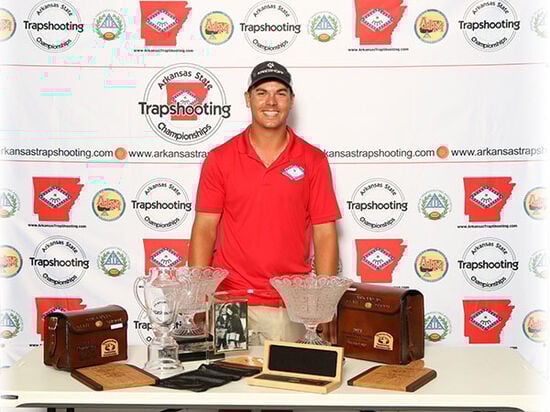 Logan Henry standing behind a table with his trophies