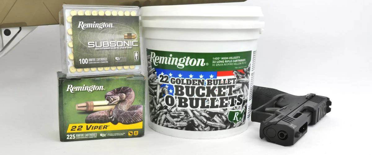 Remington Subsonic, 22 Viper, and 22 Golden Bullet package on a table next to a handgun