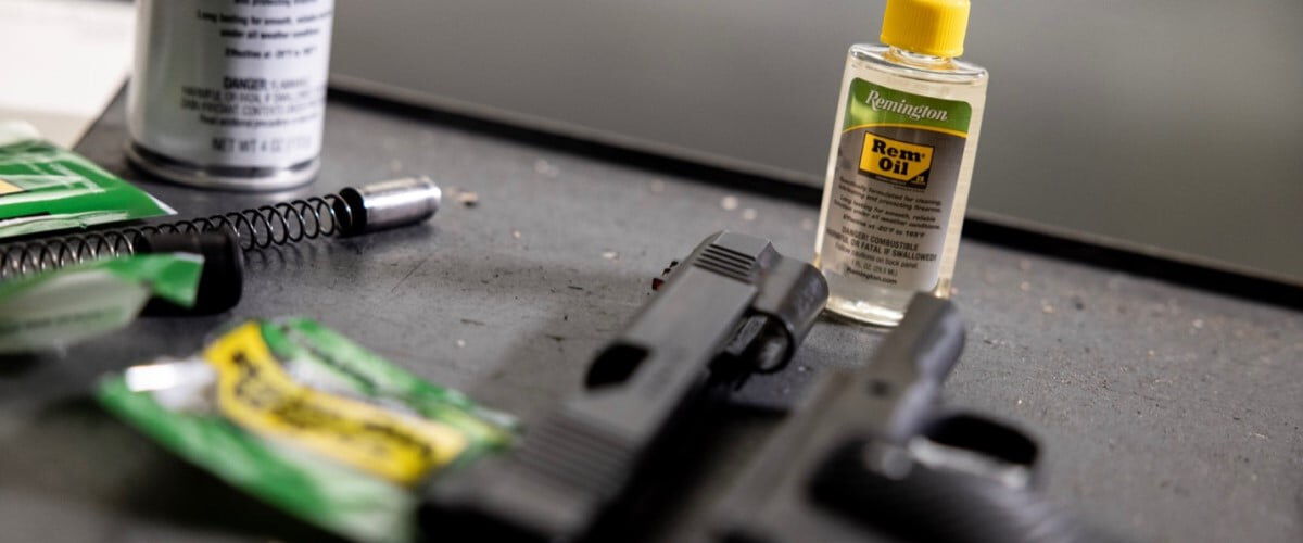 Rem Oil bottle next to a pistol taken apart for cleaning