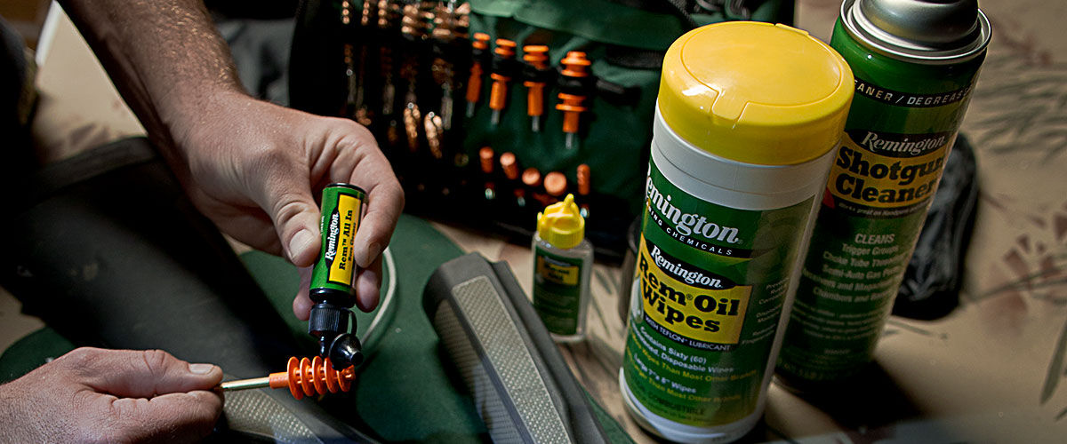 person cleaning firearm with wipes, shotgun cleaner