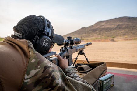 Guy holding a rifle outside