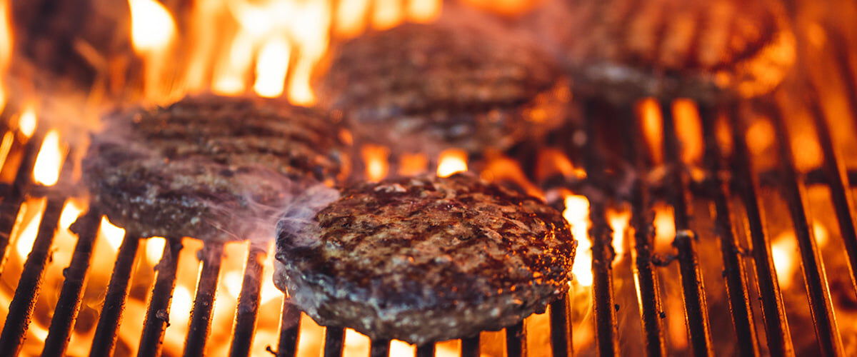 burgers cooking on a grill