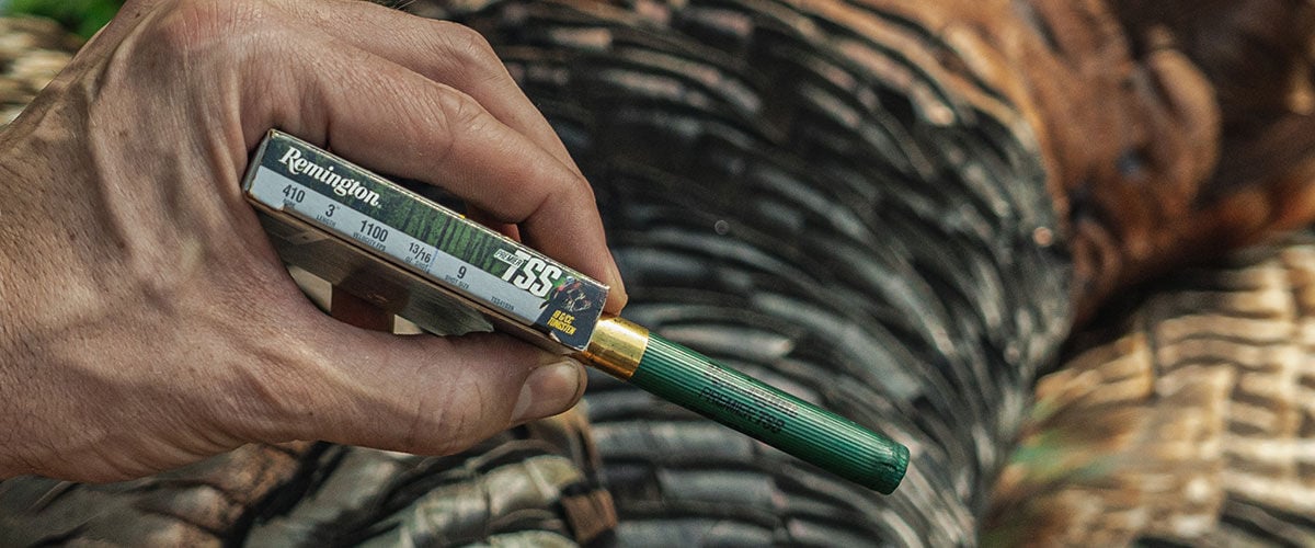hunter holding Premier TSS box and shotshell in front of turkey