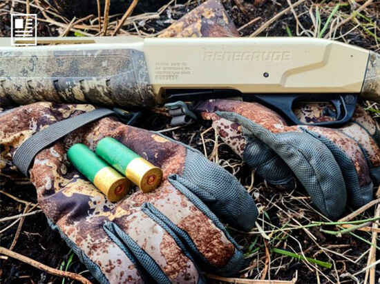 Remington Premier Bismuth laying on a glove in the grass with a shotgun
