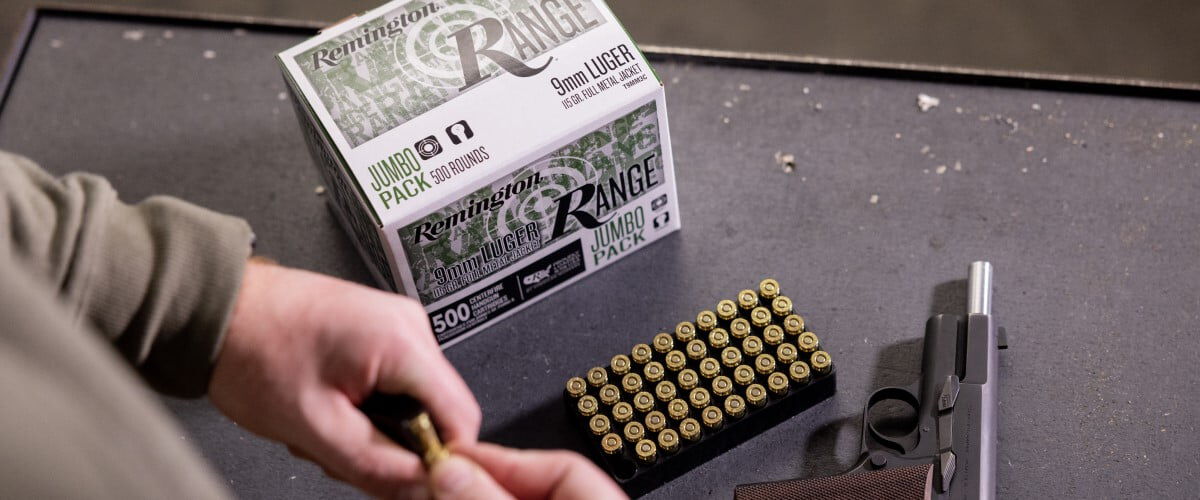 Remington Range box and cartridge tray sitting on a table with a handgun
