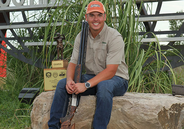 Logan Henry holding shotgun and trophy