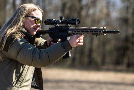 female shooter aiming a rifle