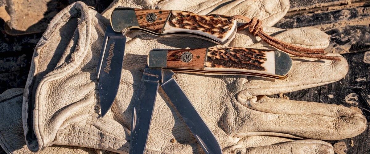 two Remington knives sitting on a pair of gloves