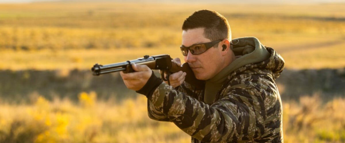 shooter looking down the iron sights of a lever action rifle