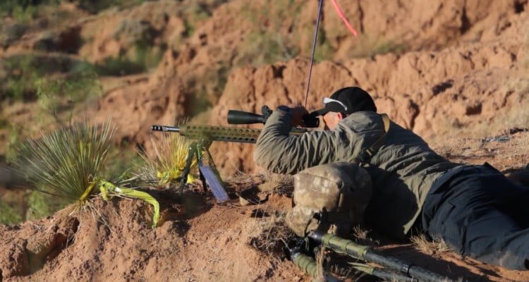 shooting looking down the scope of a rifle while in a prone position