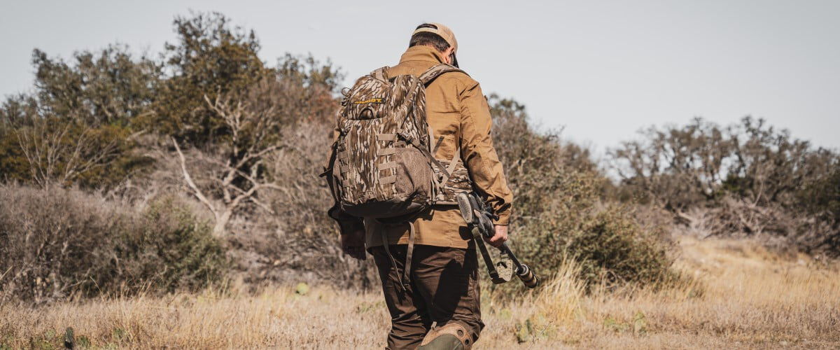 hunter walking away from while carying a rifle