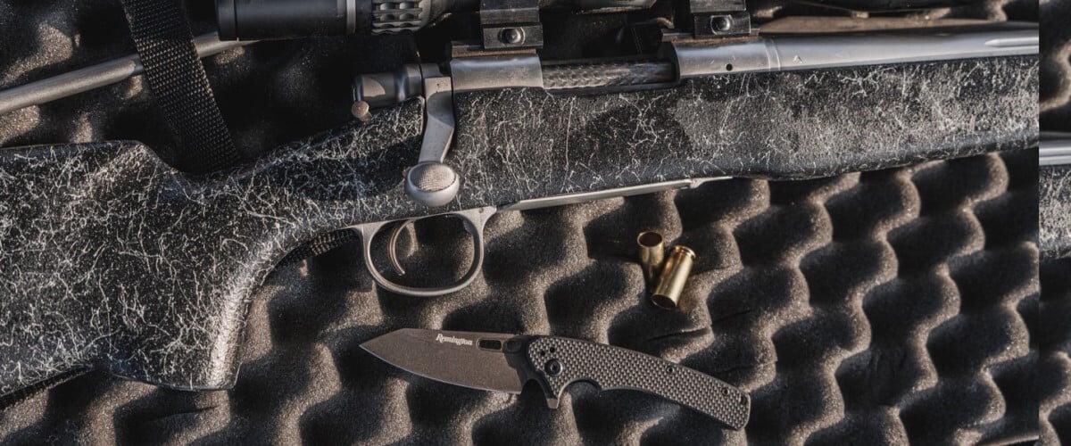 Remington knife laying in a gun case next to a rifle