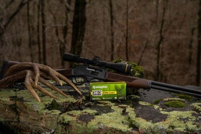 Core-Lokt 360 Buckhammer box laying on a mossy rock with a rifle and a deer antler close-up zoomed out