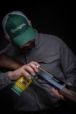 person spraying Rem Oil into firearm