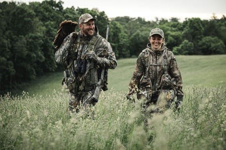 two hunters walking in a field